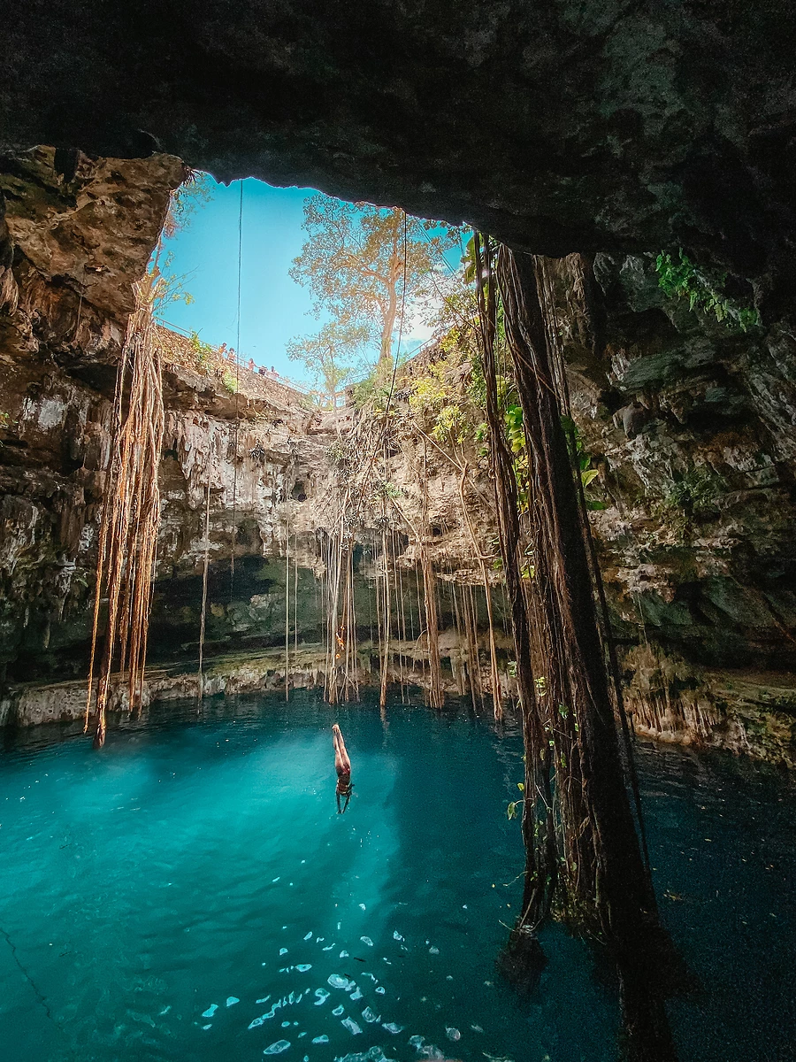 Une personne plongeant dans un cénote à Tulum, Mexique