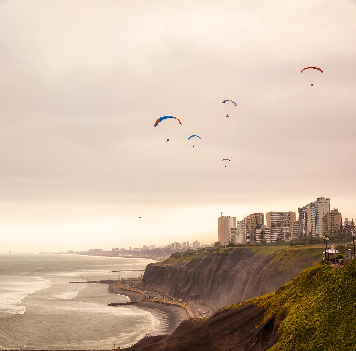 Parapentistes au-dessus de la côte à Lima, Pérou